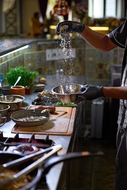 Foto der küchenchef fügt parmesan hinzu. der prozess des kochens von spaghetti mit meeresfrüchten