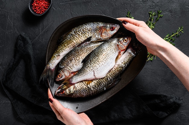 Der Küchenchef hält einen Teller Karausche. Fluss-Bio-Fisch. Ansicht von oben.