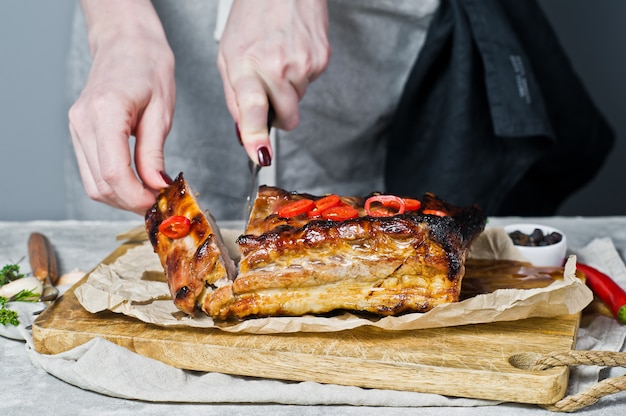 Der Küchenchef schneidet die Schweinerippchen.