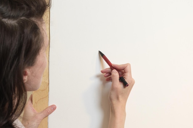 Der Künstler zeichnet mit Bleistift auf eine weiße Leinwand Blick von hinter der Schulter