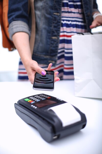 Der Kunde bezahlt mit dem Smartphone im Geschäft mithilfe der NFC-Technologie NFC-Technologie Der Kunde bezahlt