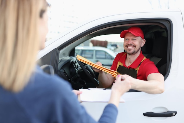 Der Kurier sitzt im Auto und übergibt der Frau das Paket