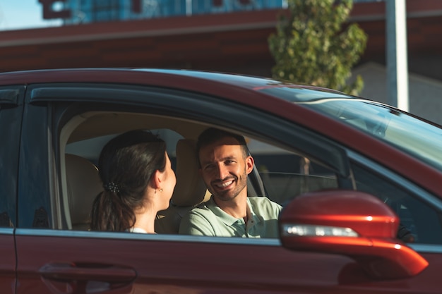 Der lächelnde Mann und die Frau, die im Auto sitzen