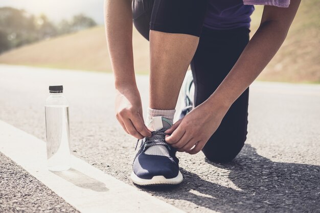 Der Läufer, der Laufschuhe binden wird, wird zum Rennen auf Laufspurstoßtraining Wellness concep fertig