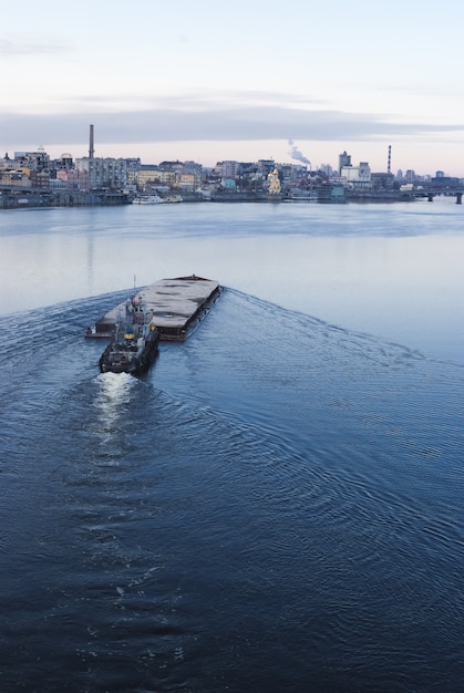 Der Lastkahn schwimmt im Dnepr. Kyiv Stadtlandschaft im Hintergrund. 17.11.2018