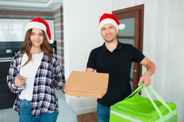 Der Lebensmittellieferant in der roten Weihnachtsmütze brachte der Frau Ordnung