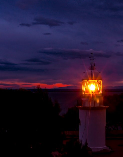 Der Leuchtturm leuchtet in der dunklen Nacht an der spanischen Küste