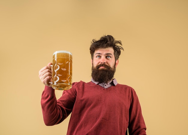 Der männliche Bierbrauer des Oktoberfest-Festivals hält ein Glas mit Bier. Oktoberfest schmeckt frisch gebraut