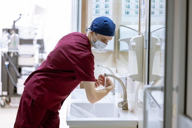 Foto der männliche chirurg wäscht sich vor der operation die hände, die sterilen hände des arztes