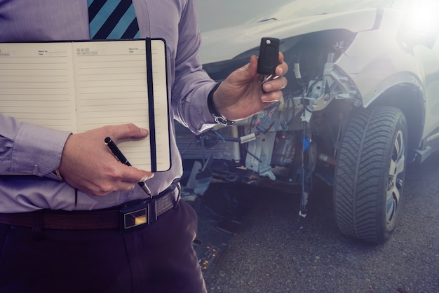 Der Manager akzeptiert das kaputte Auto zur Reparatur beim Autohaus.