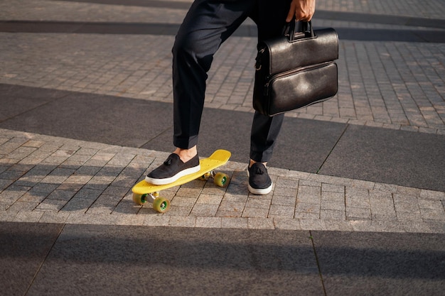 Der Manager fährt mit einem Skateboard ins Büro Ein Geschäftsmann geht zur Arbeit