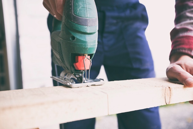 Der Mann arbeitet mit Holz