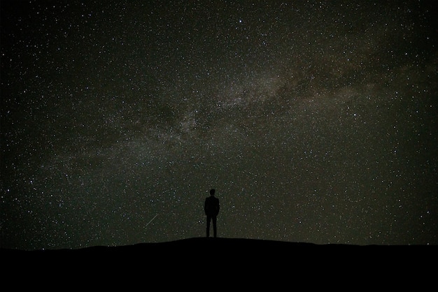 Der Mann, der auf dem Hintergrund der Sterne steht