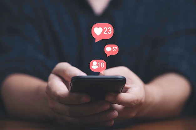 Der Mann, der ein Smartphone mit Social-Media-Symbol verwendet, umfasst eine ähnliche Nachricht und einen menschlichen Kontakt für Online-Marketing-Technologie und ein Kontaktkonzept