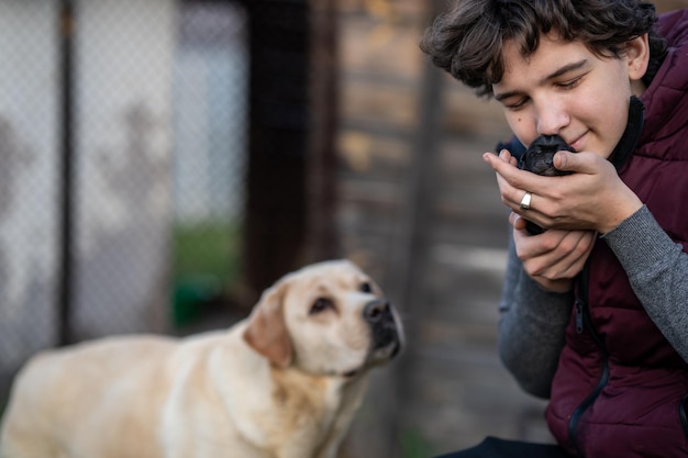 Foto der mann drückt den welpen sanft an sein gesicht. der hund. die mutter macht sich sorgen um den welpen.