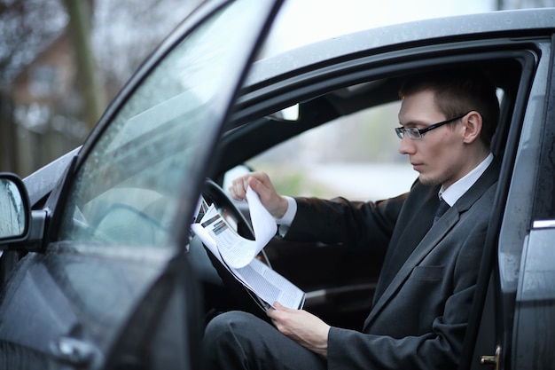 Der Mann im Anzug sitzt im Auto