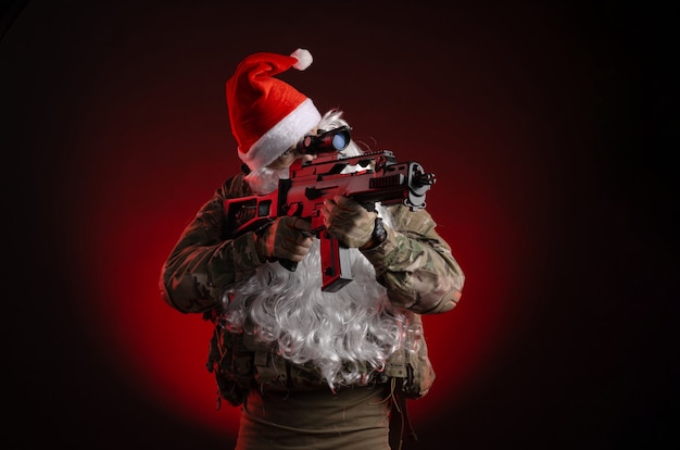 Der Mann in Militäruniform mit Pistole und Weihnachtsmannmütze