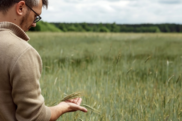 Der Mann ist ein Bauer, der auf seinem Feld steht.