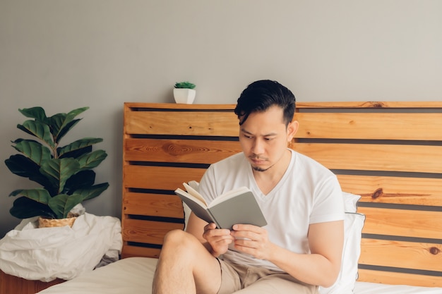 Der Mann liest am späten Nachmittag ein Buch auf seinem Bett.