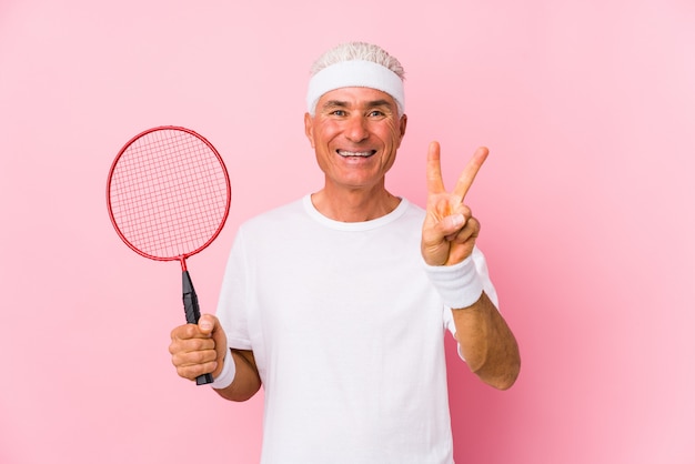 Der Mann mittleren Alters, der Badminton spielt, lokalisierte das Zeigen des Nummer zwei mit den Fingern.