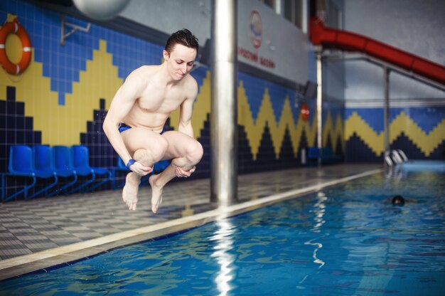 Der Mann springend in Swimmingpool