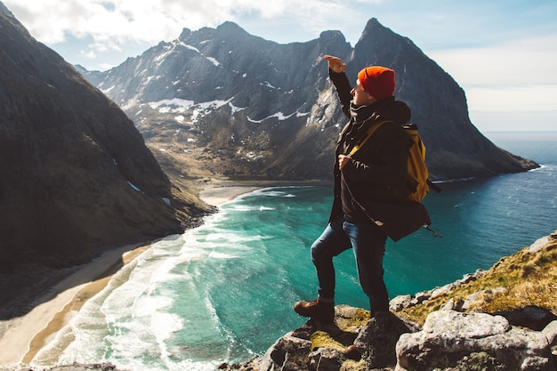 Der Mann steht allein am Rand der Klippe und genießt einen Outdoor-Urlaub mit Luftbild-Rucksack-Abenteuer