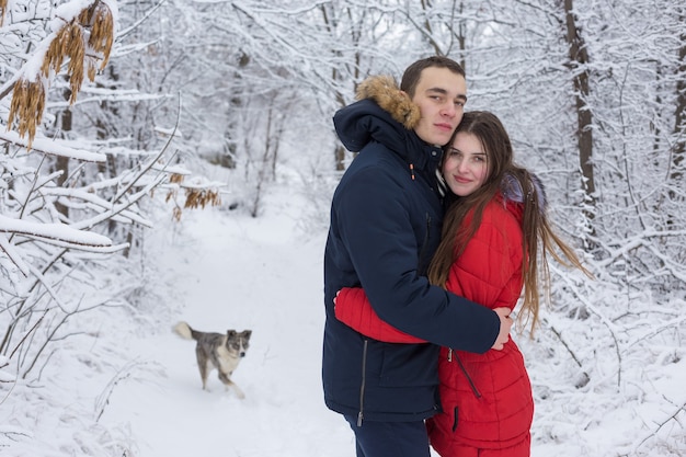Der Mann und das Mädchen erholen sich im Winterwald Mann und Frau im Schnee Junges Paar