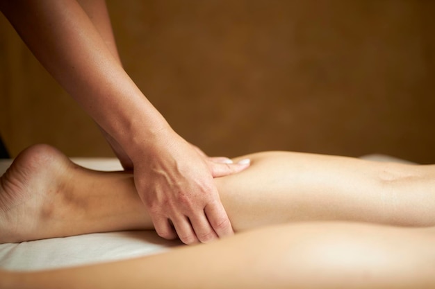 Der Masseur macht aus einer Anti-Cellulite-Beinmassage eine Anti-Cellulite-Fußmassage für Frauen