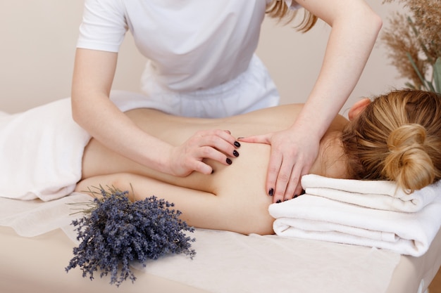 Der Masseur massiert den Rücken der Frau zur Entspannung. Aromatherapie