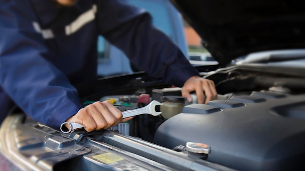 Der Mechaniker arbeitet am Motor des Autos in der Werkstatt