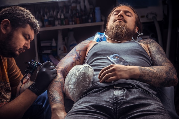 Der Meister macht Tattoo-Bilder im Tattoo-Studio.