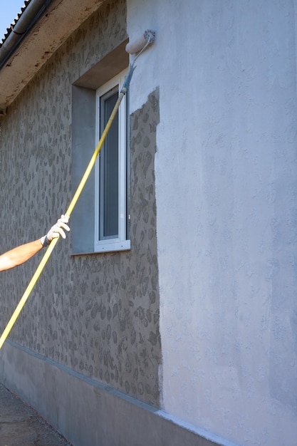 Der Meister malt die Fassade des Hauses weiß