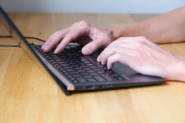 Der Mensch arbeitet am Notebook und tippt auf der Tastatur des Laptops