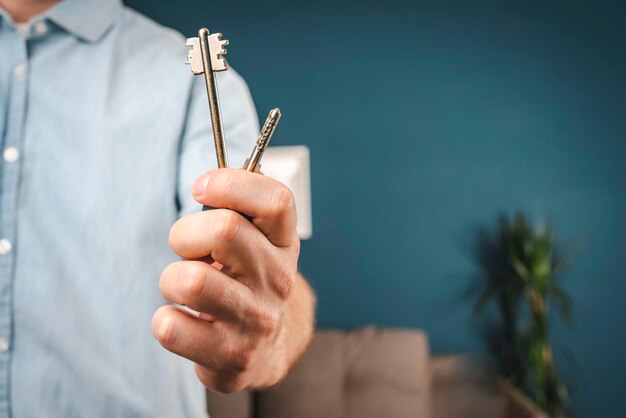 Der Mensch hält einen Hausschlüssel in der Hand, den Schlüssel zum Neuen