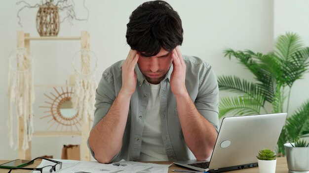 Der Mensch hat Schwierigkeiten aufgrund von Müdigkeit während der Arbeit im Büro