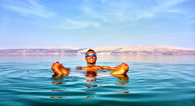 Der Mensch liegt im Toten Meer. Jordanien auf einem Hintergrund. Israel