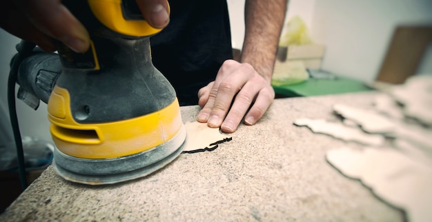 Der Mensch verarbeitet mit Holz eine Poliermaschine