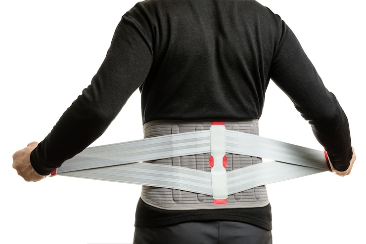 Foto der mensch zieht isoliert ein orthopädisches korsett an