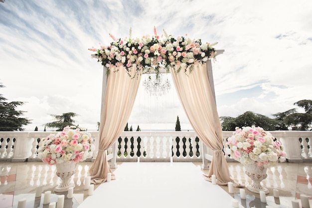 Der mit Blumen geschmückte Hochzeitsbogen steht im luxuriösen Bereich der Trauung