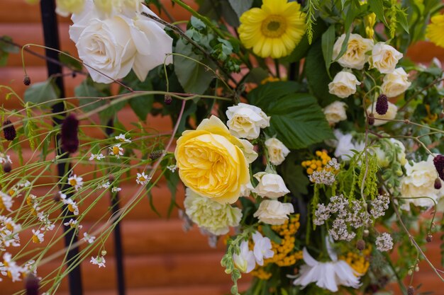 Der mit Stoffblumen und Grün geschmückte Bogen für die Hochzeitszeremonie befindet sich in einem Kiefernwald.