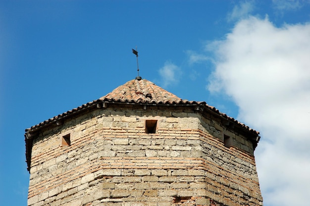 Der mittelalterliche Festungsturm mit Ziegeldach auf Hintergrund des blauen Himmels