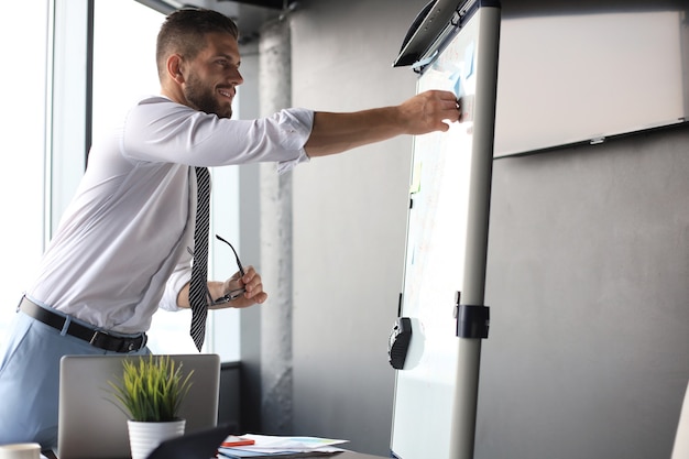 Der moderne Geschäftsmann verwendet Flipchart im Büro.