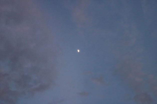 Der Mond am Abendhimmel zwischen Wolken