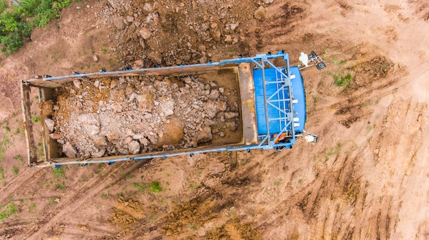 Der Muldenkipper entlädt den Boden auf der Baustelle. Luftaufnahme