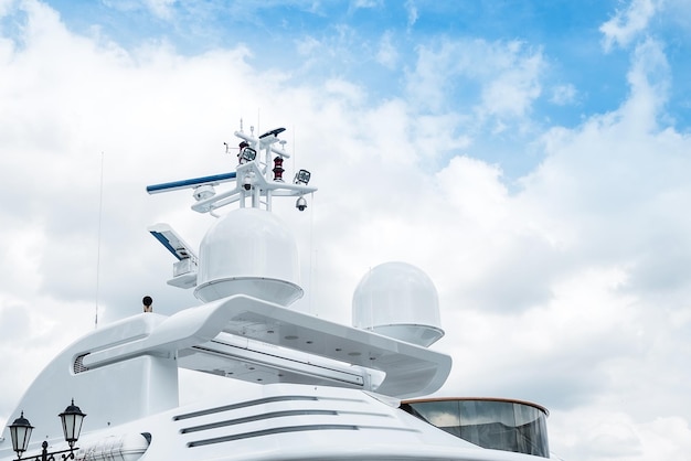 Der obere Teil ist das Dach einer luxuriösen weißen Yacht vor einem bewölkten Himmel