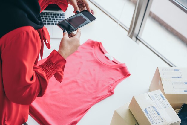 Der Online-Verkäufer arbeitet zu Hause im Büro und verpackt die Versandbox an den Kunden.