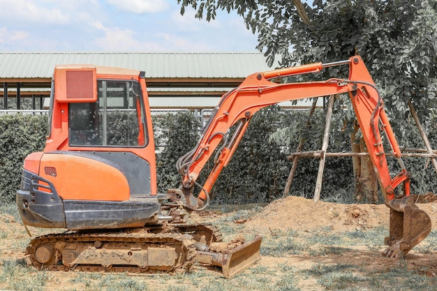 Foto der orangefarbene mini-baggerstopp auf der baustelle