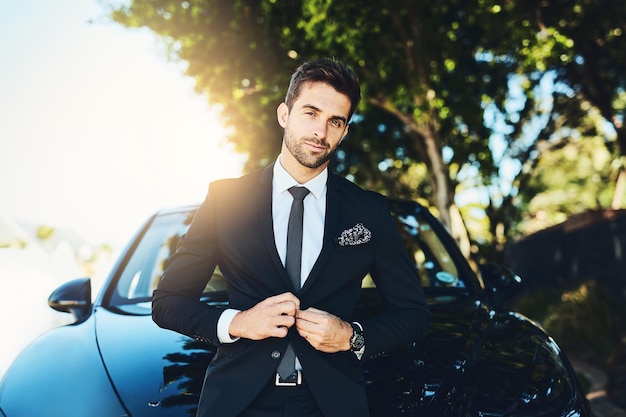 Der perfekte Anzug und das perfekte Auto, jetzt ist es an der Zeit, sie zu erobern Schnappschuss eines gutaussehenden jungen Geschäftsmanns