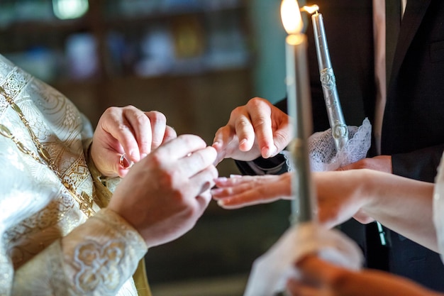 Der Pfarrer hilft dem Brautpaar beim Ringtausch bei der Trauung in der Kirche