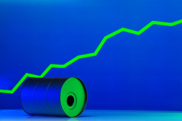 Foto der preis für amerikanisches öl ändert das konzept. schwarzes fass mit öl und grafik auf dunkelblau